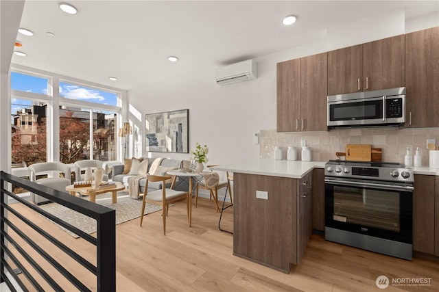 1206C NW 83rd St, Seattle, WA 98117 - kitchen featuring stainless steel appliances, a wall unit AC, light countertops, tasteful backsplash, and recessed lighting