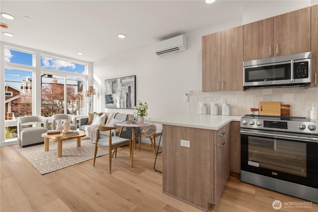 1206C NW 83rd St, Seattle, WA 98117 - kitchen featuring stainless steel appliances, a wall unit AC, tasteful backsplash, light wood-type flooring, and recessed lighting