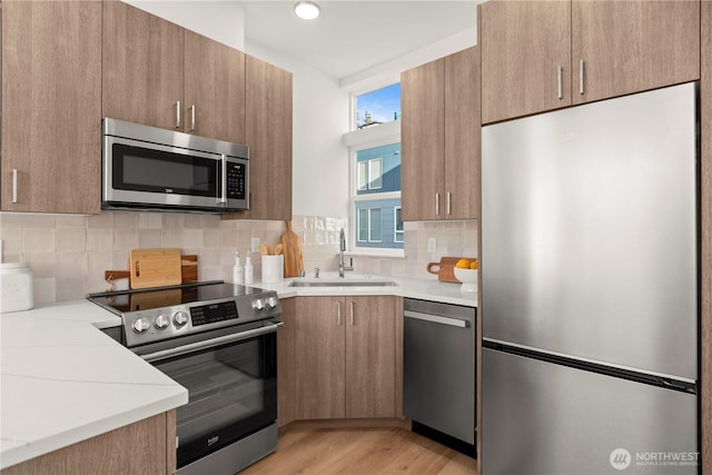 1206C NW 83rd St, Seattle, WA 98117 - kitchen with stainless steel appliances, a sink, light countertops, and decorative backsplash