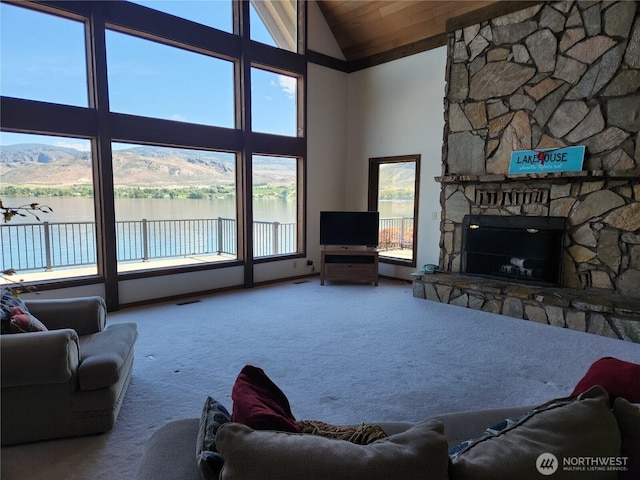 56 Westlake Rd, Oroville, WA 98844 - carpeted living room featuring a stone fireplace, high vaulted ceiling, and a mountain view