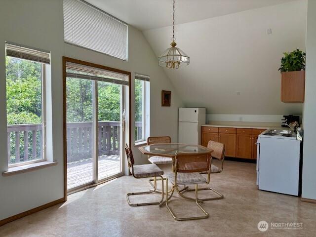 56 Westlake Rd, Oroville, WA 98844 - dining space featuring lofted ceiling, healthy amount of natural light, a chandelier, and baseboards