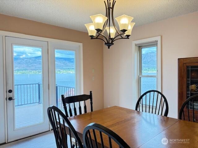 56 Westlake Rd, Oroville, WA 98844 - carpeted dining space featuring a chandelier and a textured ceiling
