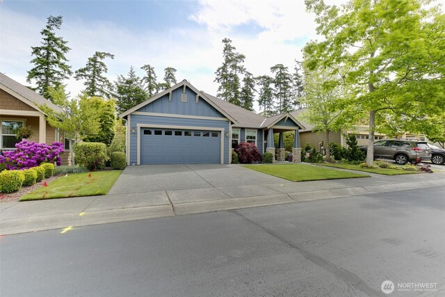 1770 SW Aberdeen Ct, Oak Harbor, WA 98277 - view of front facade featuring board and batten siding, a front lawn, a garage, and driveway