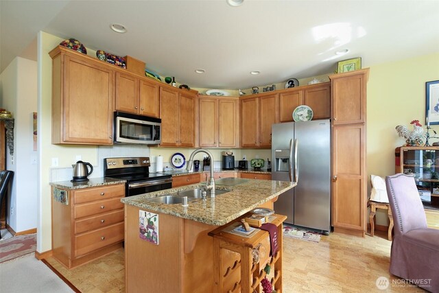 1770 SW Aberdeen Ct, Oak Harbor, WA 98277 - kitchen featuring appliances with stainless steel finishes, a sink, light stone counters, recessed lighting, and a center island with sink