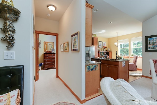 1770 SW Aberdeen Ct, Oak Harbor, WA 98277 - hallway featuring light colored carpet, a sink, baseboards, and a chandelier