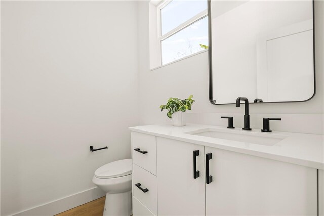 6730 21st Ave SW, Seattle, WA 98106 - bathroom with vanity, toilet, wood finished floors, and baseboards