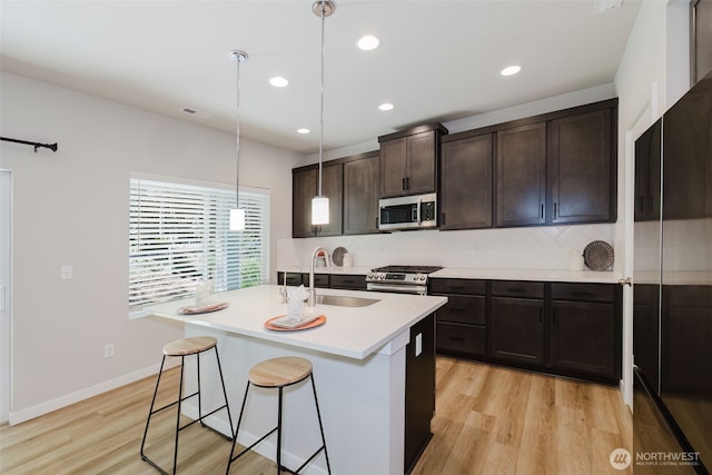 9422 Fairhaven Cir NE, Bremerton, WA 98311 - kitchen with appliances with stainless steel finishes, a sink, light wood finished floors, decorative backsplash, and light countertops