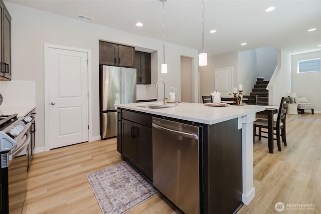 9422 Fairhaven Cir NE, Bremerton, WA 98311 - kitchen featuring appliances with stainless steel finishes, a sink, light countertops, light wood-type flooring, and dark brown cabinetry