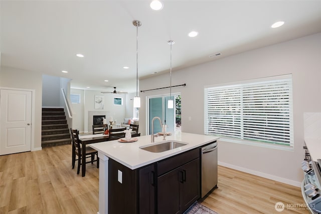9422 Fairhaven Cir NE, Bremerton, WA 98311 - kitchen with a sink, stainless steel dishwasher, light wood-style flooring, a glass covered fireplace, and light countertops