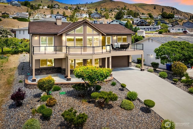 205 Butte Rd, Chelan, WA 98816 - view of front of house featuring a residential view, stone siding, a mountain view, and driveway
