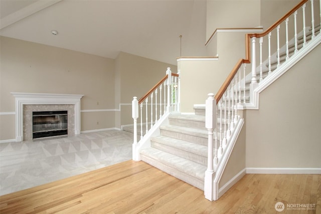 5318 Galleon Dr NE, Tacoma, WA 98422 - staircase featuring wood finished floors, baseboards, a towering ceiling, and a tile fireplace