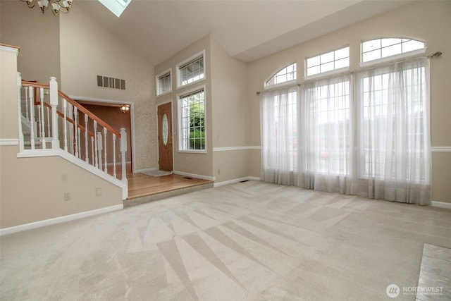 5318 Galleon Dr NE, Tacoma, WA 98422 - entrance foyer featuring stairway, high vaulted ceiling, carpet, baseboards, and a skylight