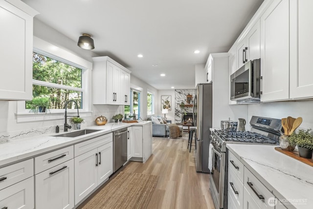 27302 NE 153rd Pl, Duvall, WA 98019 - kitchen with appliances with stainless steel finishes, a sink, white cabinetry, light wood finished floors, and recessed lighting