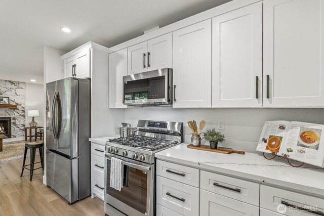 27302 NE 153rd Pl, Duvall, WA 98019 - kitchen with appliances with stainless steel finishes, light wood finished floors, white cabinets, light stone counters, and recessed lighting
