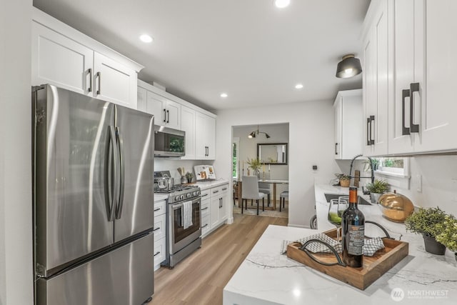 27302 NE 153rd Pl, Duvall, WA 98019 - kitchen featuring appliances with stainless steel finishes, a sink, white cabinetry, light stone counters, and recessed lighting
