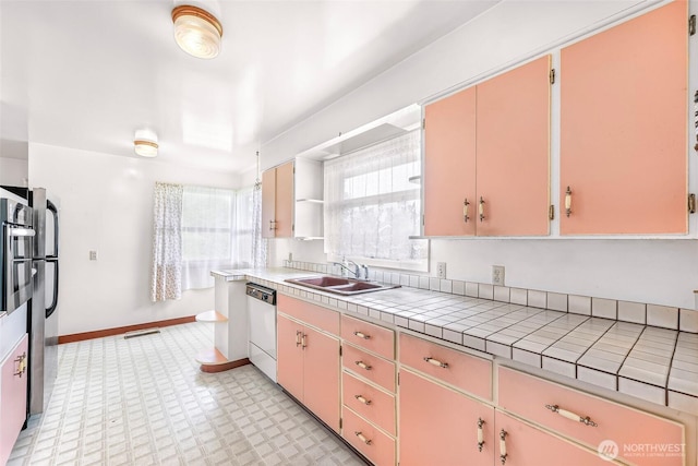 420 E Connecticut St, Bellingham, WA 98225 - kitchen featuring a sink, dishwashing machine, tile counters, light flooring, and baseboards