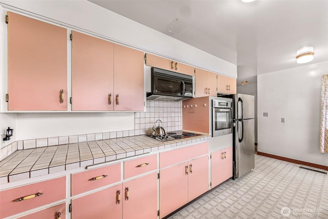 420 E Connecticut St, Bellingham, WA 98225 - kitchen featuring stainless steel appliances, tile counters, backsplash, light floors, and baseboards