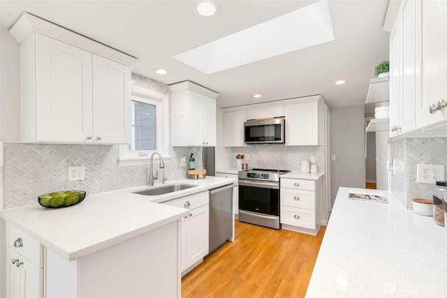 1703 NE 91st St, Seattle, WA 98115 - kitchen featuring appliances with stainless steel finishes, white cabinetry, light countertops, backsplash, and light wood-style flooring