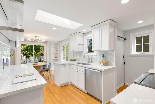 1703 NE 91st St, Seattle, WA 98115 - kitchen with dishwasher, a skylight, white cabinets, tasteful backsplash, and light wood finished floors