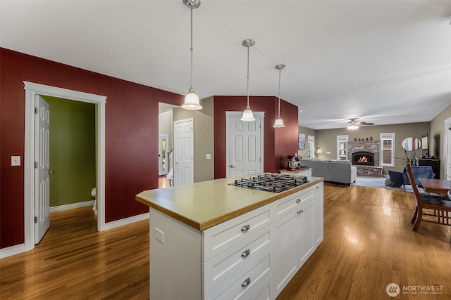 675 Bowker St SE, Lacey, WA 98503 - kitchen with gas stovetop, dark wood finished floors, a center island, white cabinetry, and decorative light fixtures