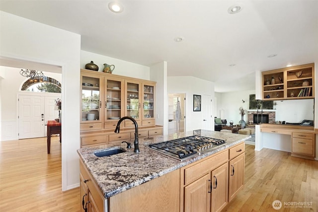1048 Cassius Ct, Camano Island, WA 98282 - kitchen with a sink, stainless steel gas cooktop, light wood-style flooring, an island with sink, and light stone countertops