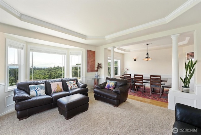 1048 Cassius Ct, Camano Island, WA 98282 - carpeted living room with ornate columns, a raised ceiling, crown molding, wainscoting, and a decorative wall