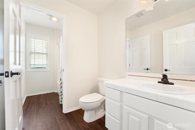 1048 Cassius Ct, Camano Island, WA 98282 - bathroom with toilet, wood finished floors, vanity, baseboards, and a shower with shower curtain