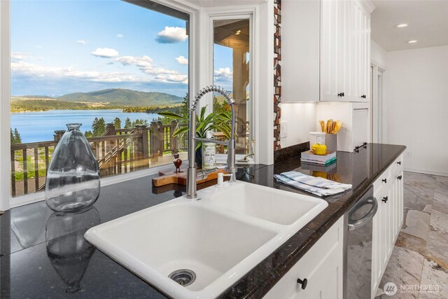 16822 SE 26th St, Bellevue, WA 98008 - kitchen with a sink, dark countertops, white cabinetry, a water view, and baseboards