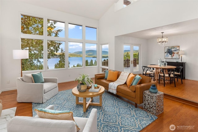 16822 SE 26th St, Bellevue, WA 98008 - living area featuring a chandelier, wood finished floors, baseboards, a water view, and a towering ceiling