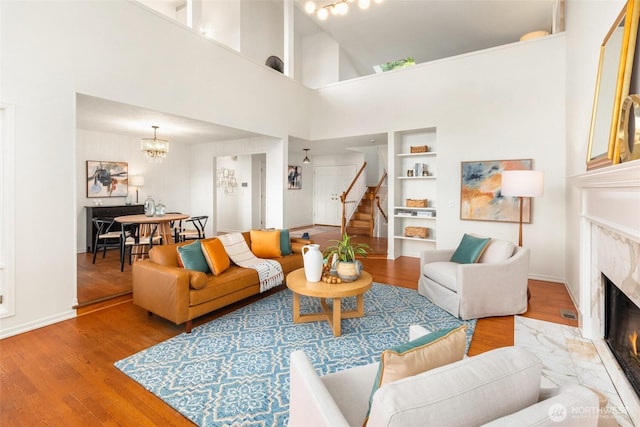 16822 SE 26th St, Bellevue, WA 98008 - living room featuring a fireplace, stairs, wood finished floors, a towering ceiling, and baseboards