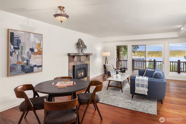 16822 SE 26th St, Bellevue, WA 98008 - dining room featuring plenty of natural light, a fireplace, wood finished floors, a textured ceiling, and baseboards