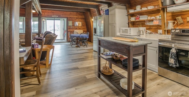 568 Cowlitz Ct SW, Ocean Shores, WA 98569 - kitchen featuring appliances with stainless steel finishes, open shelves, light countertops, wooden walls, and light wood finished floors