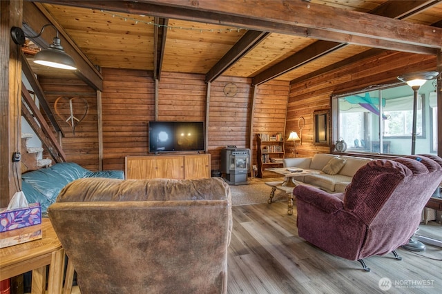 568 Cowlitz Ct SW, Ocean Shores, WA 98569 - living area with wooden ceiling with exposed beams, wooden walls, wood finished floors, and a wood stove