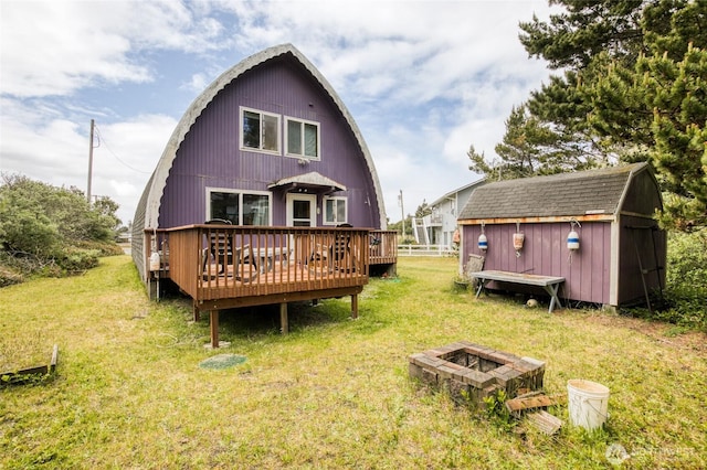 568 Cowlitz Ct SW, Ocean Shores, WA 98569 - rear view of property featuring an outdoor fire pit, a gambrel roof, a yard, and a deck