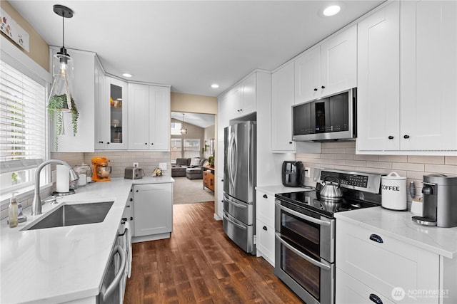 1317 60th St SE Unit A, Auburn, WA 98092 - kitchen featuring appliances with stainless steel finishes, a sink, backsplash, dark wood-type flooring, and white cabinets