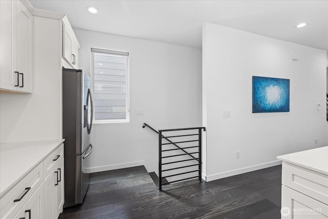 6055 7th Ave NW, Seattle, WA 98107 - kitchen with stainless steel refrigerator with ice dispenser, dark wood-style flooring, white cabinetry, light countertops, and baseboards