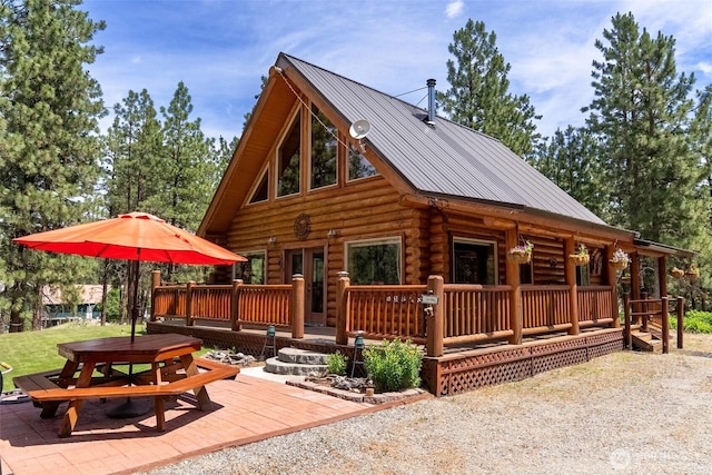 21 Oakes Dr, Tonasket, WA 98855 - rear view of house featuring log siding, outdoor dining area, and a metal roof
