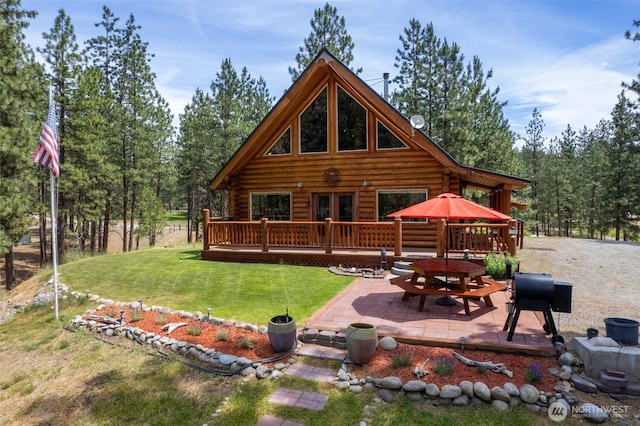 21 Oakes Dr, Tonasket, WA 98855 - back of house featuring log siding, a patio area, a wooden deck, a lawn, and french doors