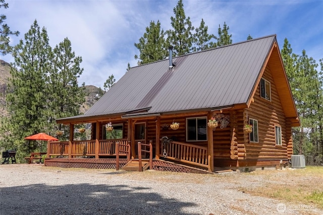 21 Oakes Dr, Tonasket, WA 98855 - log-style house featuring covered porch, log siding, and a metal roof
