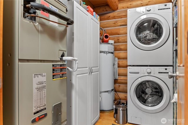 21 Oakes Dr, Tonasket, WA 98855 - laundry room featuring rustic walls, estacked washer and dryer, heating unit, strapped water heater, and light wood-type flooring