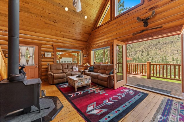 21 Oakes Dr, Tonasket, WA 98855 - living area featuring a wood stove, high vaulted ceiling, wood-type flooring, rustic walls, and wood ceiling