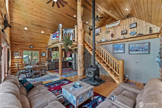 21 Oakes Dr, Tonasket, WA 98855 - living room with a ceiling fan, high vaulted ceiling, rustic walls, wood ceiling, and a wood stove