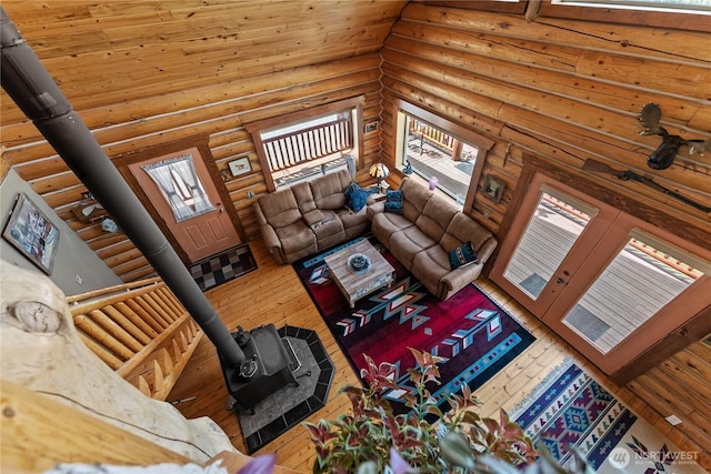 21 Oakes Dr, Tonasket, WA 98855 - living room featuring a wood stove, rustic walls, hardwood / wood-style flooring, healthy amount of natural light, and a high ceiling