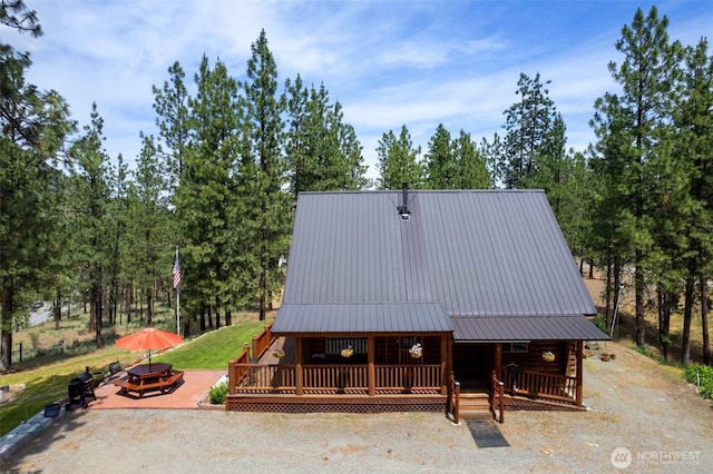 21 Oakes Dr, Tonasket, WA 98855 - view of front of property featuring an outdoor fire pit, a metal roof, a deck, and view of scattered trees