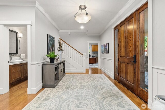 4825 Bayshore Ln NW, Olympia, WA 98502 - foyer with ornamental molding, stairs, and light wood-style floors