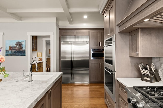 4825 Bayshore Ln NW, Olympia, WA 98502 - kitchen featuring appliances with stainless steel finishes, a sink, beam ceiling, light wood finished floors, and recessed lighting