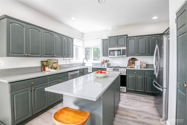 7117 Axis St SE, Lacey, WA 98513 - kitchen featuring appliances with stainless steel finishes, a kitchen breakfast bar, light wood finished floors, a center island, and recessed lighting
