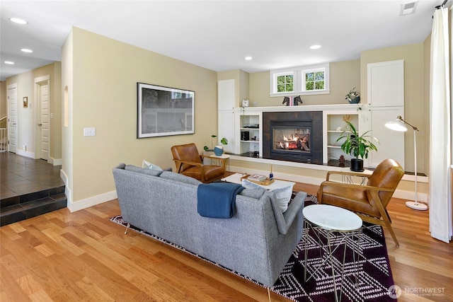 301 Weaver Rd NW, Bainbridge Island, WA 98110 - living room with wood finished floors, a tiled fireplace, baseboards, and recessed lighting