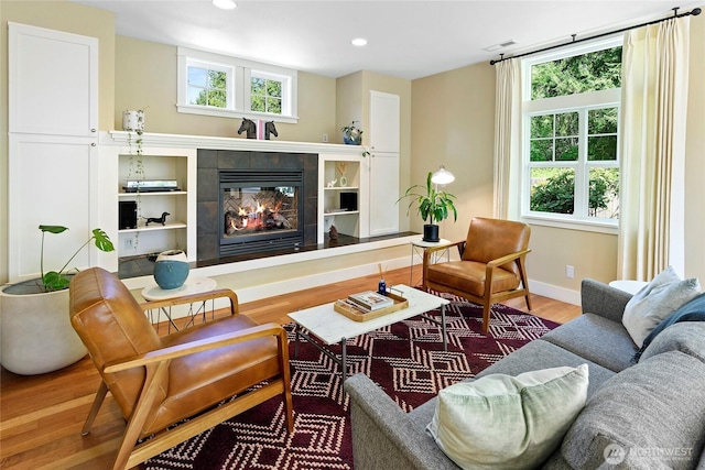 301 Weaver Rd NW, Bainbridge Island, WA 98110 - living area with wood finished floors, a tiled fireplace, baseboards, and recessed lighting