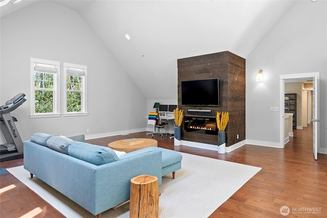 301 Weaver Rd NW, Bainbridge Island, WA 98110 - living room featuring vaulted ceiling, baseboards, and wood finished floors